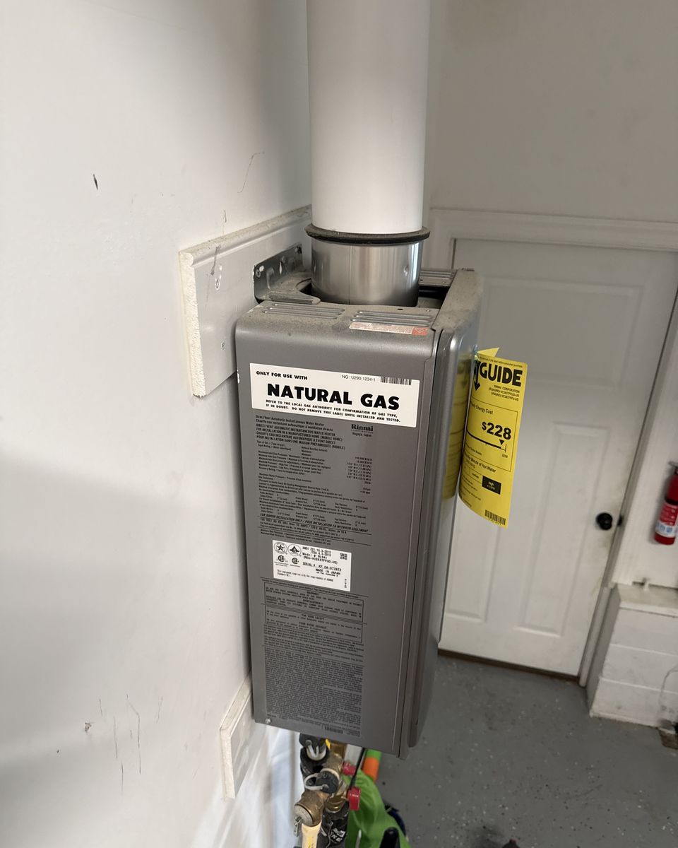 Side of a tankless water heater showing its natural gas label and a single vent pipe